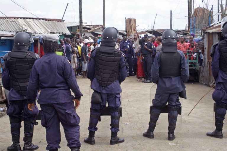 Liberian security forces with riot gear stop people from leaving the West Point area, that has been hardest hit by the Ebola virus spreading in Monrovia, Liberia, Monday, Aug. 25, 2014. A Liberian doctor who was among three Africans to receive an experimental Ebola drug has died, the country's information minister said Monday.(AP Photo/Abbas Dulleh)