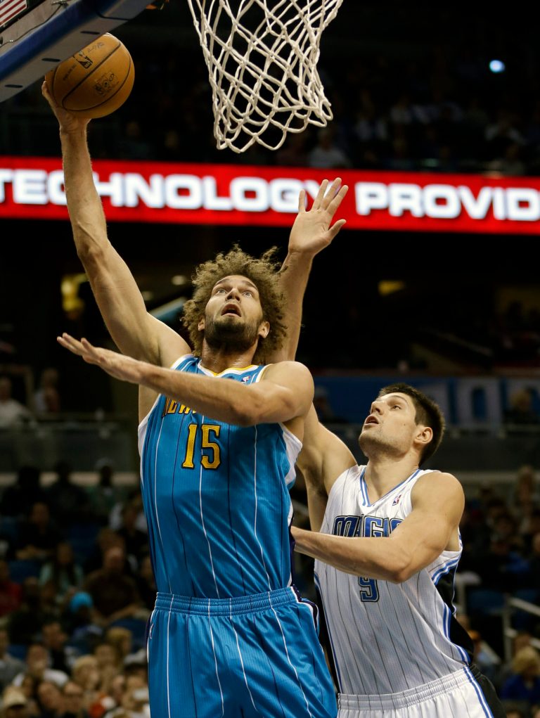   New Orleans Hornets' Robin Lopez (15) gets off a shot in front of Orlando Magic's Nikola Vucevic (9), of Montenegro, during the first half of an NBA basketball game on Wednesday, Dec. 26, 2012, in Orlando, Fla. (AP Photo/John Raoux)  