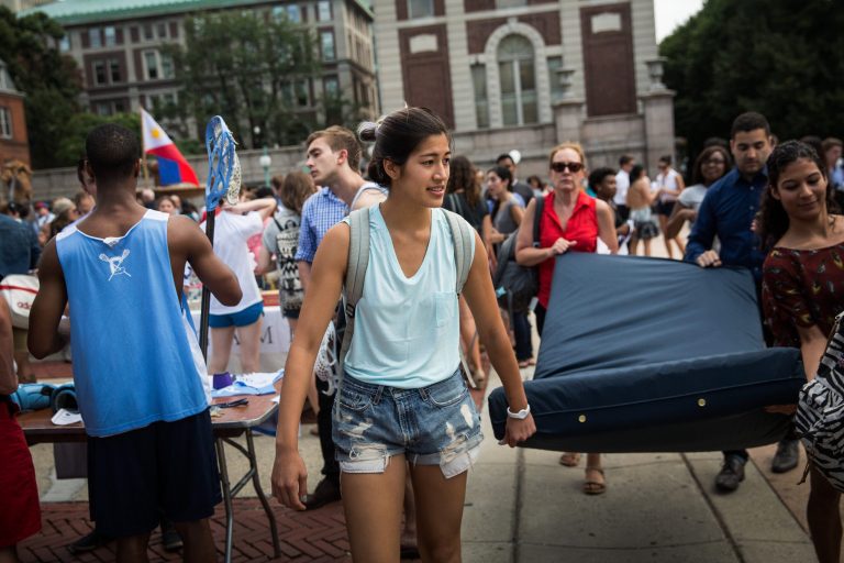 Emma Sulkowicz, a senior visual arts student at Columbia University, carries a mattress, with the help of three strangers who met her moments before, in protest of the university's lack of action after she reported being raped during her sophomore year on September 5, 2014 in New York City. (Photo by Andrew Burton/Getty Images)