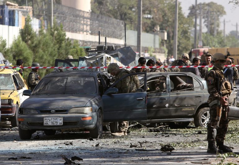 NATO and Afghan security forces inspect the site of a suicide attack in Kabul, Afghanistan, Tuesday, Sept. 16, 2014.  A Taliban suicide car bomber attacked a foreign motorcade just a couple hundred yards (meters) from the U.S. Embassy, unleashing a blast that injured at least 13 people and rattled nearby neighborhoods, police officials said. (AP Photo/Rahmat Gul)