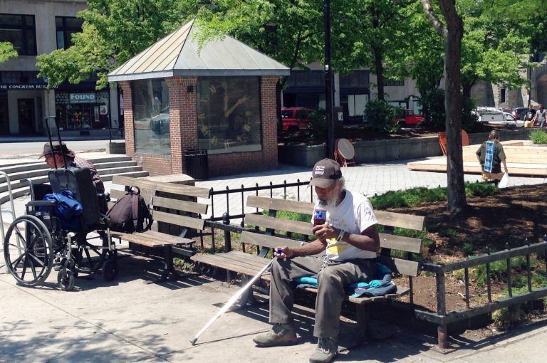 People sit on benches in Congress Square Plaza Monday, June 9, 2014, in Portland, Maine. A squabble over the city's desire to sell the half-acre park to an Ohio-based hotel owner evolved into a larger debate and into Tuesday's ballot referendum on the future of the city's many public parks. (AP Photo/Patrick Whittle)