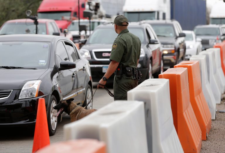 A U.S. Customs and Border Patrol agent  and K-9 security dog keep watch at a checkpoint station, Friday, Feb. 22, 2013, in Falfurrias, Texas. (AP Photo/Eric Gay)