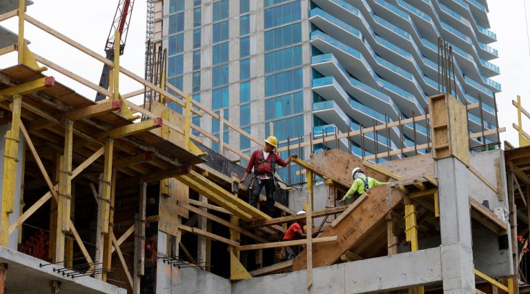 In this photo taken Tuesday, July 22, 2014, builders work at the construction site of a 36-floor high rise condominium in Miami. Financial market conditions, a big rise in applications for building permits and falling applications for unemployment benefits were the biggest sources of strength in July, according to the Conference Board's index of leading indicators released Thursday, Aug. 21, 2014. (AP Photo/Alan Diaz)
