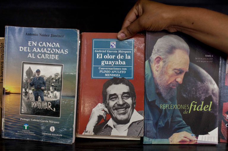 A woman shows a book by Colombian author Gabriel Garcia Marquez for sale next to a book by Fidel Castro at a state-run bookstore in Havana, Cuba, Thursday, April 17, 2014. Garcia Marquez, who died at his home in Mexico City on Thursday, became a hero to the Latin American left as an early ally of Cuba's revolutionary leader Fidel Castro.  (AP Photo/Franklin Reyes)