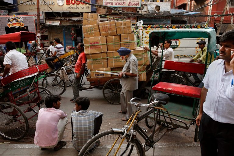 An elderly Sikh man, center, checks his mobile phone as he walks through a busy street in New Delhi, India, Tuesday, Aug. 19, 2014. (AP Photo /Manish Swarup)