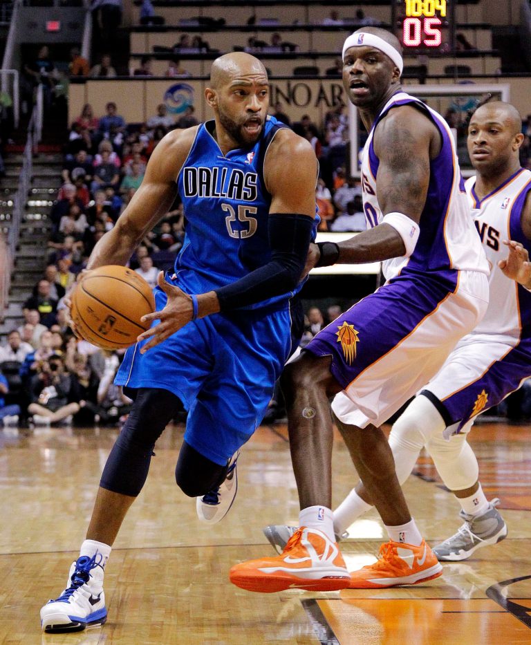   Dallas Mavericks' Vince Carter (25) drives past Phoenix Suns' Jermaine O'Neal during the first half of an NBA basketball game, Thursday, Dec. 6, 2012, in Phoenix. (AP Photo/Matt York)  