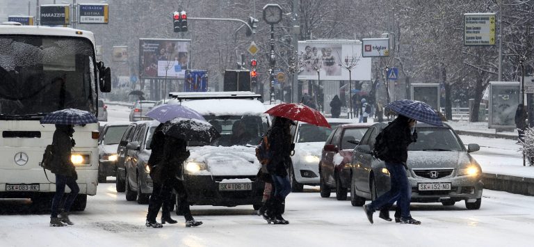   People cross a street covered with snow and ice in Skopje, Macedonia, on Tuesday, Dec. 11, 2012. The weather forecast predicts continuing snowfall and low temperatures for the next days in Eastern Europe. (AP Photo/Boris Grdanoski)  