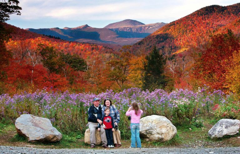 FILE - In this Oct. 6, 2006 file photo, flowers, fall foliage and 6,288-foot Mt. Washington serve as a backdrop for a family picture at Crawford Notch State Park in New Hampshire.  (AP Photo/Robert F. Bukaty, File)