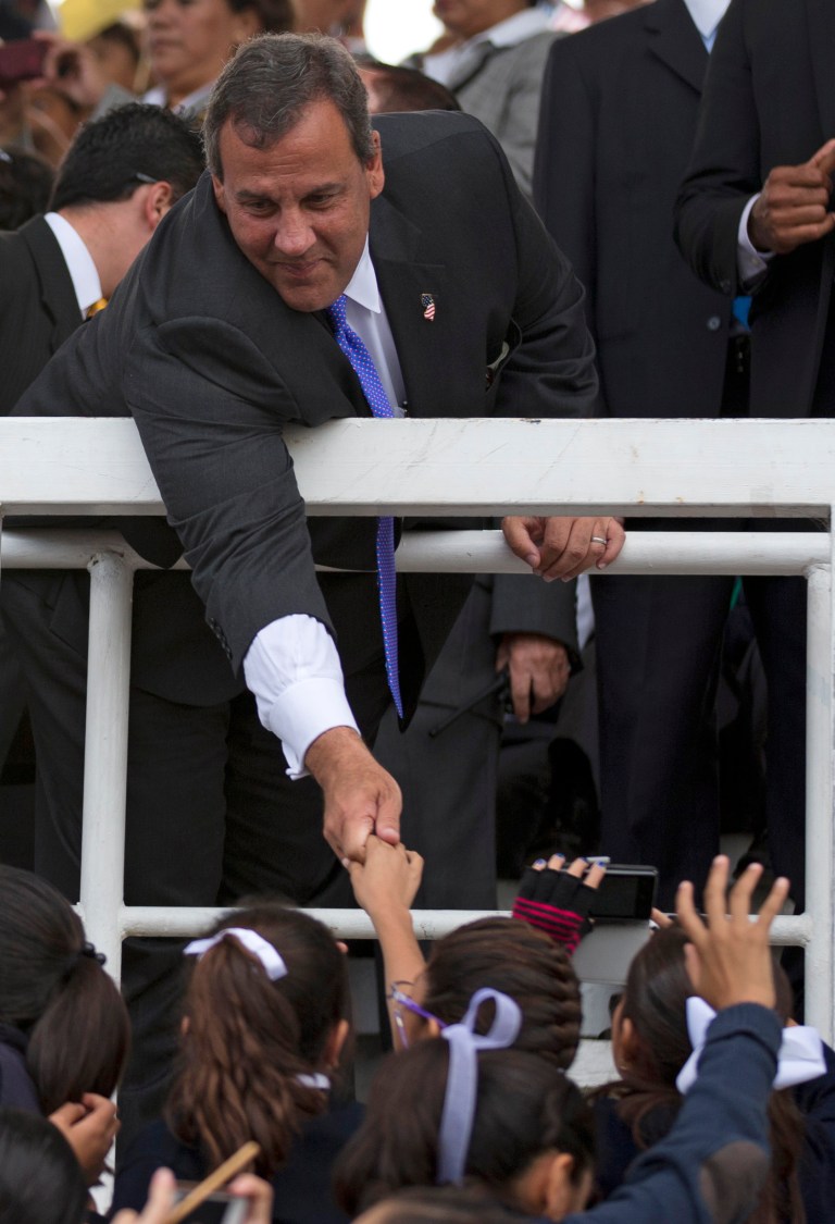 New Jersey Gov. Chris Christie reaches over a stadium railing to shake hands with cheering students as he visits a school in Puebla, Mexico, Friday, Sept. 5, 2014. On the last day of Christie's three-day visit to Mexico, the potential 2016 contender put his people skills to the test in the city of Puebla, where students packed the bleachers of an outdoor field waving Mexican, American, and New Jersey Flags. (AP Photo/Rebecca Blackwell)