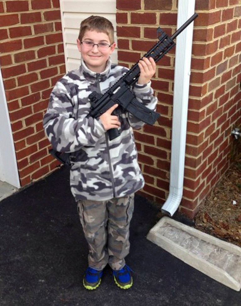 This undated photo provided by Shawn Moore shows his son Josh, 11, holding a rifle his father gave him as a birthday present, at their home in Carneys Point, N.J. The Moore family claims this photo, posted on Facebook, led the state's child welfare agency to the family's house, Friday, March 15, 2013, demanding to be let inside to inspect their guns. (AP Photo/Shawn Moore)