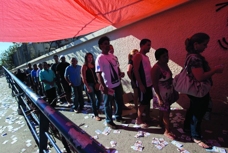 People wait in line to vote in municipal elections outside a polling station in the Complexo da Mare slum in Rio de Janeiro, Brazil, Sunday, Oct. 7, 2012. Voters across Latin America's biggest country are electing mayors and municipal council members. (AP Photo/Silvia Izquierdo)
