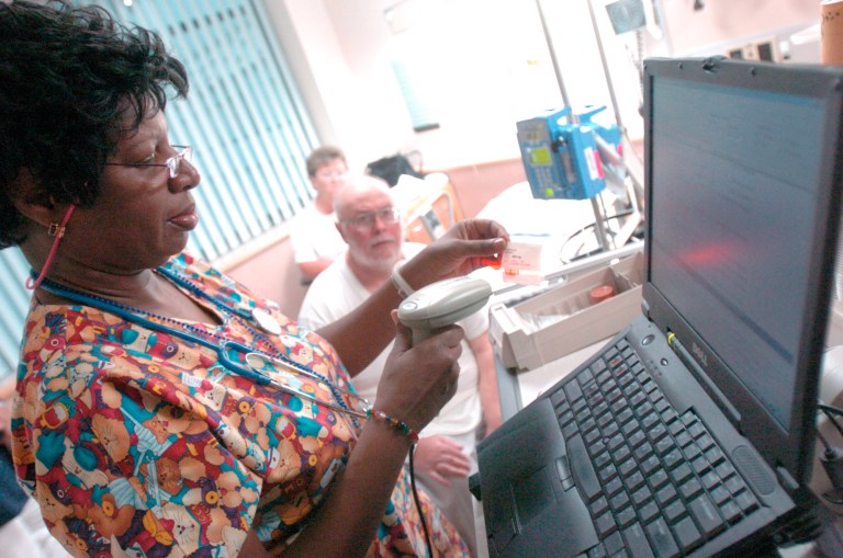 Patricia Rose, left, a registered nurse at the Veterans Affairs Medical Center in Baltimore scans a barcode before dispensing medicine to VA patient Allen Smith of Romney, WVa., Tuesday April 27, 2004. (AP Photo/Don Wright)