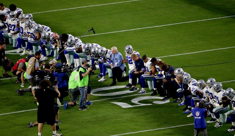 The Dallas Cowboys, led by owner Jerry Jones, center, take a knee prior to the national anthem prior to an NFL football game against the Arizona Cardinals, Monday, Sept. 25, 2017, in Glendale, Ariz. (AP Photo/Matt York)