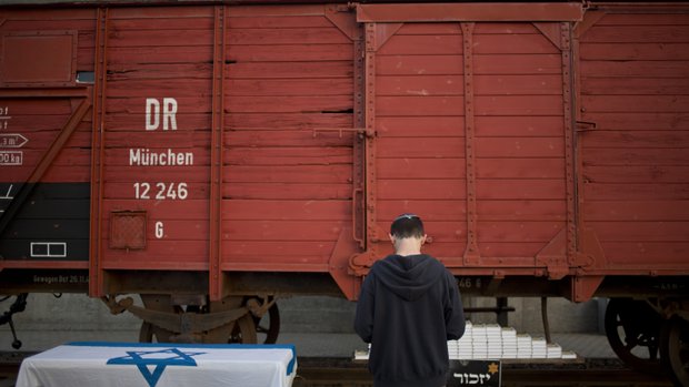 A man prays next to a wagon from WWII on display on the eve of Holocaust Remembrance Day in Netanya, Israel, Wednesday, April 15, 2015. The wagon was used to transport Jews to death camps. AP Photo