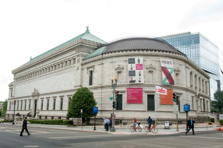 FILE - This May 15, file photo shows pedestrians passing the Corcoran Gallery of Art in Washington. Attorneys are set to make closing arguments in a case that will determine the future of one of the nation's oldest museums and one of the few independent art galleries in the nation's capital. Trustees of the Corcoran Gallery of Art are seeking to merge the museum and its college into George Washington University and the National Gallery of Art, dissolving the independent Corcoran after years of financial troubles. A group of current students and faculty has fought the merger in court, arguing there are ways to save the Corcoran. (AP Photo/Kevin Wolf, File)
