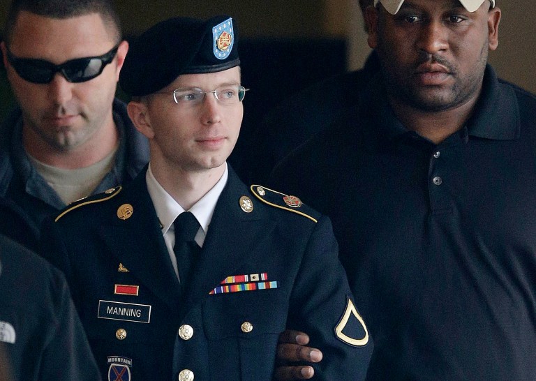 Army Pfc. Bradley Manning is escorted to a security vehicle outside a courthouse in Fort Meade, Md., after a hearing in his court martial. (AP Photo/Patrick Semansky, File)