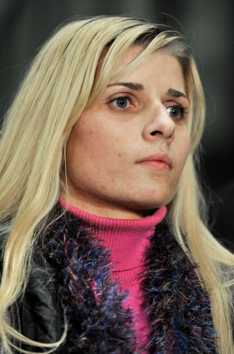   FILE - In this Nov. 13, 2012 file photo, bartender Karolina Obrycka, who was beaten in February 2007 by off-duty Chicago police officer Anthony Abbate, listens while her attorney Terry Ekl speaks during a news conference in Chicago after jurors awarded her $850,000 in damages. The city of Chicago and Obrycka, whose videotaped beating by Abbate drew national attention, have taken the unusual step of asking a judge to toss a landmark civil verdict in the case. In deciding against the city last month, jurors determined some officers follow a code of silence protecting rogue colleagues like the officer involved. If the judge grants the motion, the city would forgo any appeal and pay Obrycka the full damages immediately. Otherwise, a payment could be delayed years. Striking the verdict would deny others suing the city the chance to cite it as precedent. (AP Photo/Paul Beaty, File)  