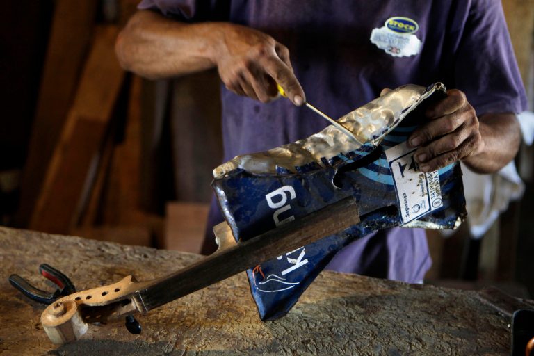   In this Dec. 11, 2012 photo, Nicolas Gomez makes a violin with recycled materials at his home in the Cateura, a vast landfill outside Paraguay's capital of Asuncion, Paraguay. Gomez, a trash picker and former carpenter, was asked by Favio Chavez, the creator of Ã¬The Orchestra of Instruments Recycled From Cateura,