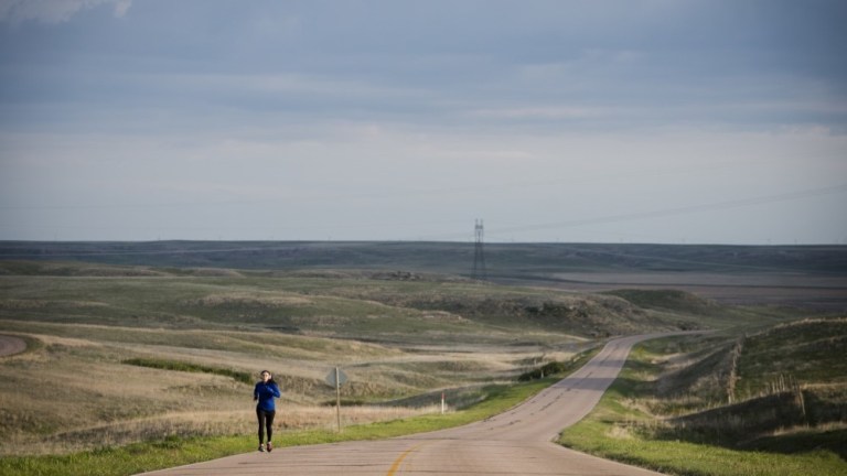 Airman 1st Class Alexandra Ayub runs on a road near the missile alert facility in Nebraska during a four-day deployment in 2016. Although Ayub works within a fenced in facility, she does her physical training outside of the gates in the vast expanse of open land that surrounds the Missile Alert Facility.