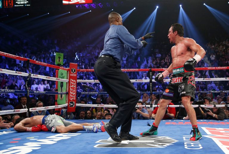   Referee Kenny Bayless, center, sends Juan Manuel Marquez, from Mexico, right, to his corner after Marquez knocked out Manny Pacquiao, from the Philippines, left, in the sixth inning of their WBO world welterweight fight Saturday, Dec. 8, 2012, in Las Vegas. Marquez won the fight by a knockout. (AP Photo/Eric Jamison)  