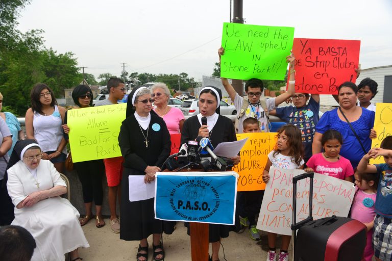 At the podium, sisters Noemia Silva (L) and Alma Huerta of the Missionary Sisters of Saint Charles Borromeo Scalabrinians address marchers in front of Club Allure Chicago, a strip club, to protest its proximity to their convent, Wednesday, June 18, 2014. (AP Photo/Chicago Sun-Times, Richard A. Chapman)
