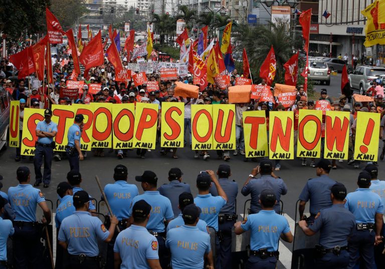 Riot police prepare to prevent protesters from marching closer to U.S. Embassy Tuesday, Feb. 25, 2014 in Manila, Philippines, against the forthcoming visit of U.S. President Barack Obama. The protesters were also calling for the pullout of U.S. troops in the country under the Visiting Forces Agreement or VFA. (AP Photo/Bullit Marquez)
