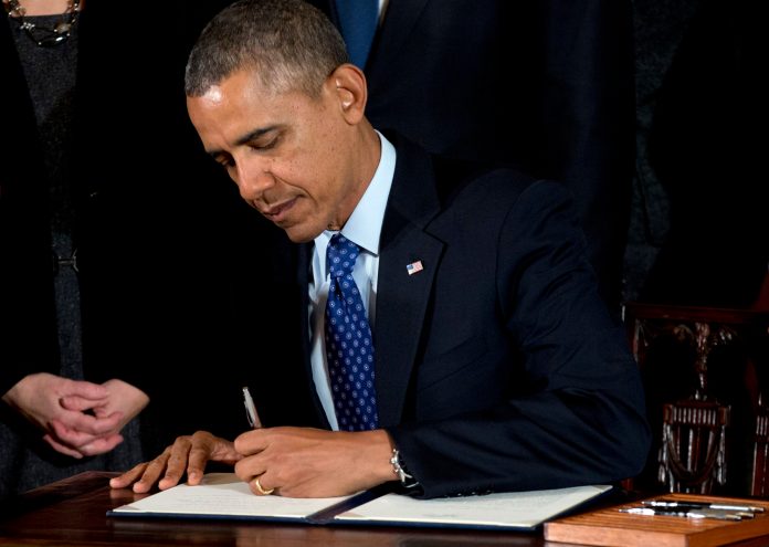 In this Jan. 22, 2014, file photo, President Obama signs a memorandum creating a task force to respond to campus rapes during an event for the Council on Women and Girls in the East Room of the White House in Washington. (AP Photo/Carolyn Kaster, File)