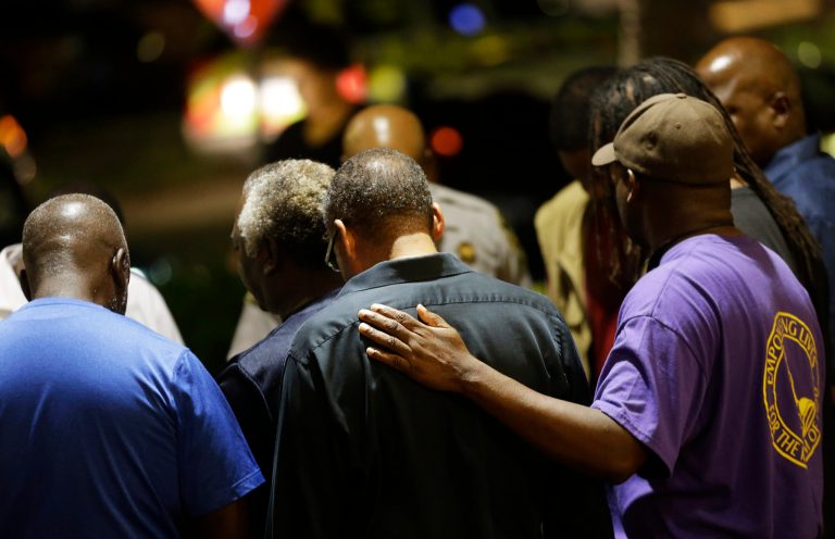 Worshippers gather to pray in a hotel parking lot across the street from the Emanuel AME Church following a shooting Wednesday, June 17, 2015, in Charleston, S.C. (AP Photo/David Goldman)