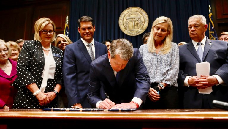 Georgiaâs Republican Gov. Brian Kemp, center, signs legislation, Tuesday, May 7, 2019, in Atlanta, banning abortions once a fetal heartbeat can be detected, which can be as early as six weeks before many women know theyâre pregnant. Kemp said he was signing the bill âto ensure that all Georgians have the opportunity to live, grow, learn and prosper in our great state.â 