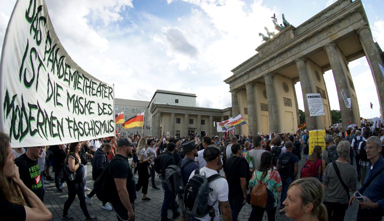 People in front of the Brandenburg Gate attend a protest rally in Berlin, Germany, Saturday, Aug. 29, 2020 against new coronavirus restrictions in Germany.
