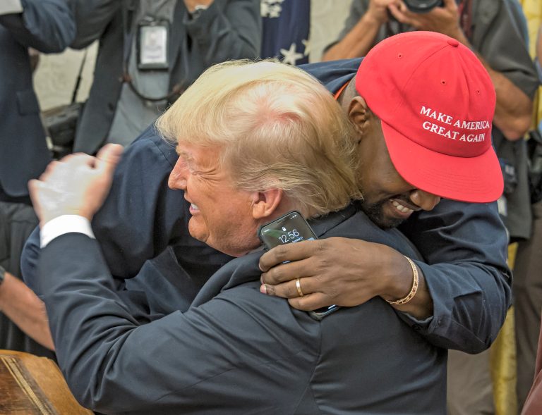 American rapper and producer Kanye West embraces real estate developer and US President Donald Trump in the White House's Oval Office, Washington DC, October 11, 2018.