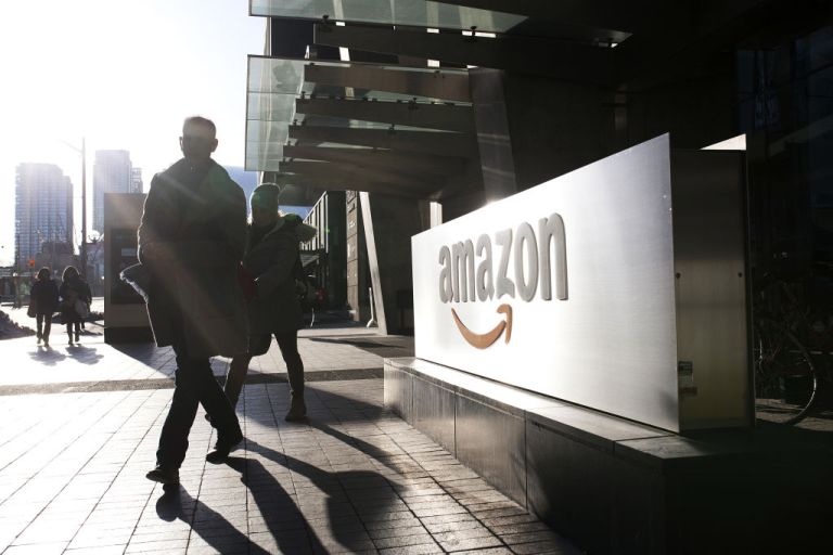 Pedestrians walks past Amazon.com Inc. headquarters in the financial district of Toronto, Ontario, Canada, on Friday, Feb. 21, 2020. 
