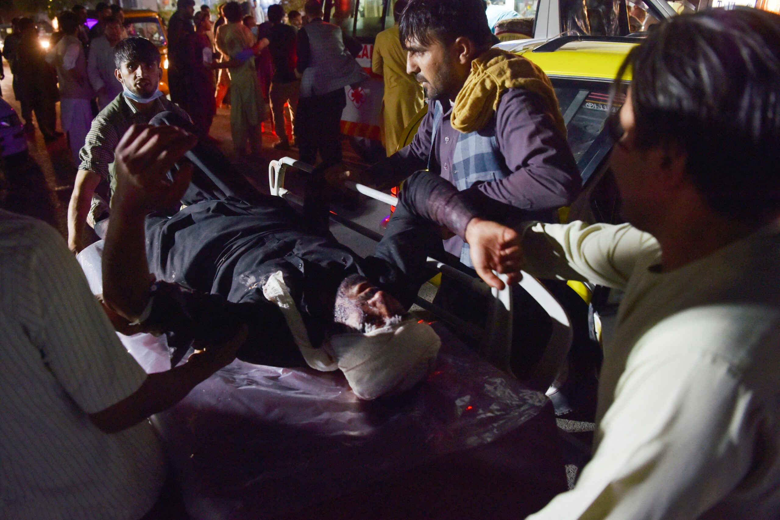 Medical and hospital staff bring an injured man on a stretcher for treatment after two blasts.