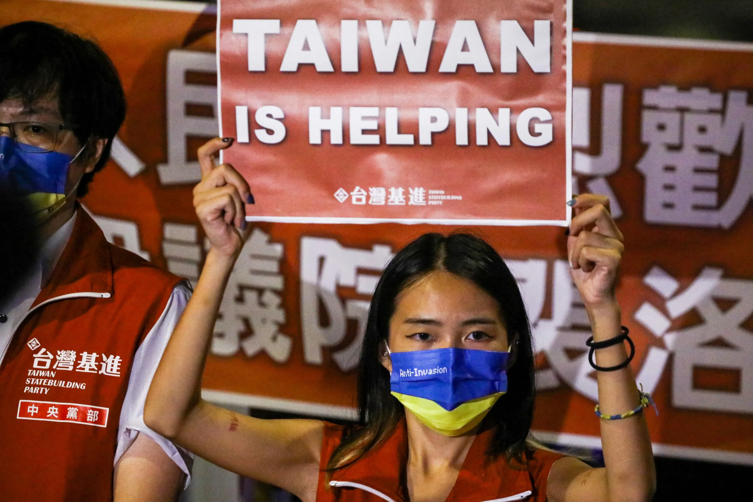 A Taiwanese woman holds a sign reading, "Taiwan is helping," in support of U.S. House Speaker Nancy Pelosi's trip to the island.