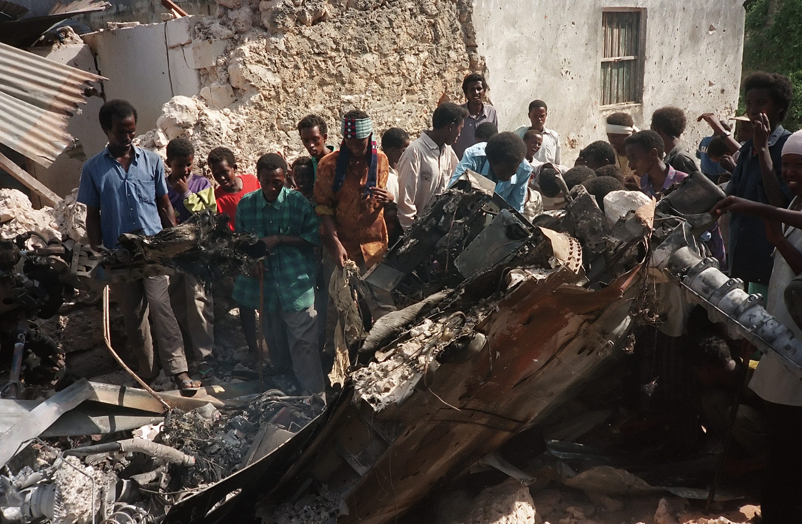 Somalis look at the wreckage of a US hel