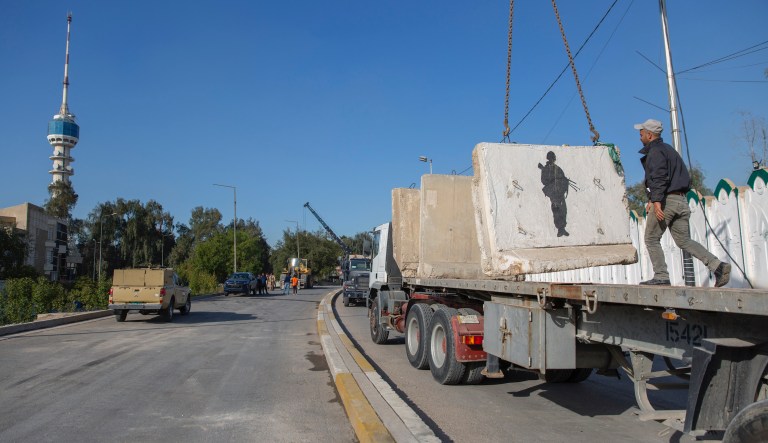 Iraqi security forces remove cement blocks and open the streets, that were closed for security concerns, around the Green Zone in Baghdad, Iraq, Thursday, Jan. 2, 2020. Iran-backed militiamen have withdrawn from the U.S. Embassy compound in Baghdad after two days of clashes with U.S. security forces.