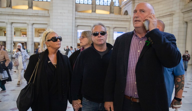 Charlotte Charles, left, mother of British teenager Harry Dunn, and her husband Bruce Charles, center arrive at Union Station in Washington, Tuesday, Oct. 15, 2019. The family of a British teenager killed in a car crash involving an American diplomat's wife was headed to the White House on Tuesday for a meeting with senior administration officials. On the phone is family spokesman Radd Seiger. 