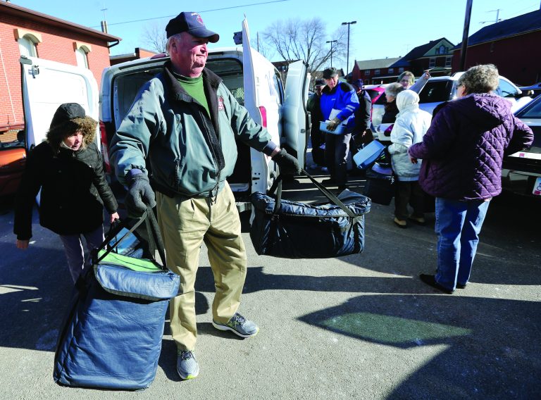 Volunteer for Meals on Wheels Ray Crippes (center), of Kieler, Wis., loads up meals before making deliveries around town Friday, Feb. 2, 2018 at St. Matthew Lutheran Church in Dubuque.
