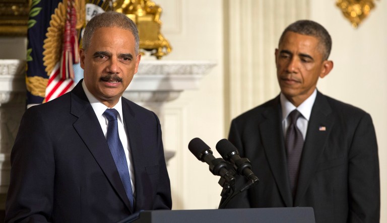 President Barack Obama, right, looks on as Attorney General Eric Holder speaks in the State Dining Room of the White House, on Thursday, Sept. 25, 2014, in Washington.