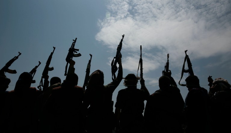 A silhouette of tribesmen loyal to Houthi rebel raise their weapons as they chant slogans during a gathering against the agreement to establish diplomatic relations between Israel and the United Arab Emirates  in Sanaa, Yemen, Saturday, Aug. 22, 2020.