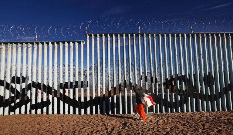 A Central American migrant walks along the border structure expecting top make an illegal crossing into the U.S., seen from the Mexican side where the border meets the Pacific Ocean, Friday, Nov. 16, 2018. 