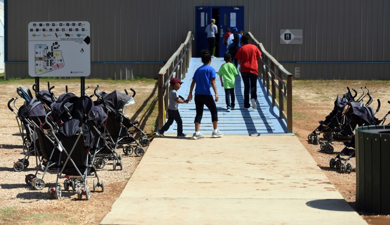 In this Thursday, Aug. 9, 2018, photo, provided by U.S. Immigration and Customs Enforcement, immigrants walk into a building at South Texas Family Residential Center in Dilley, Texas. Currently housing 1,520 mothers and their children, about 10 percent are families who were temporarily separated and then reunited under a âzero tolerance policyâ that has since been reversed.