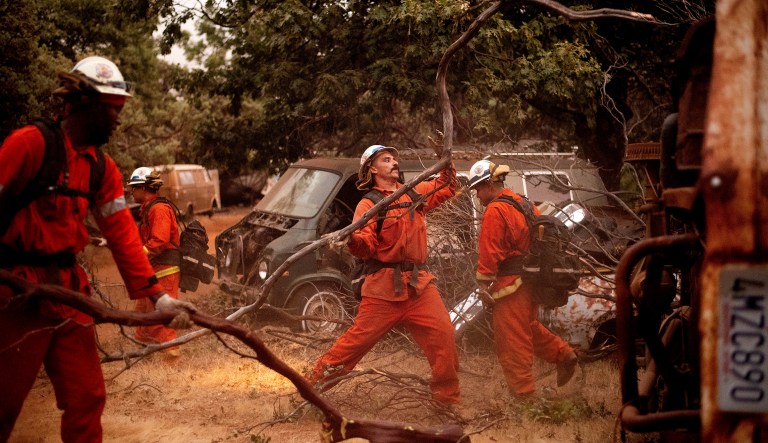 Inmate firefighters clear brush to create a fire break while battling the Ferguson Fire in unincorporated Mariposa County, Calif, on Monday, July 16, 2018.