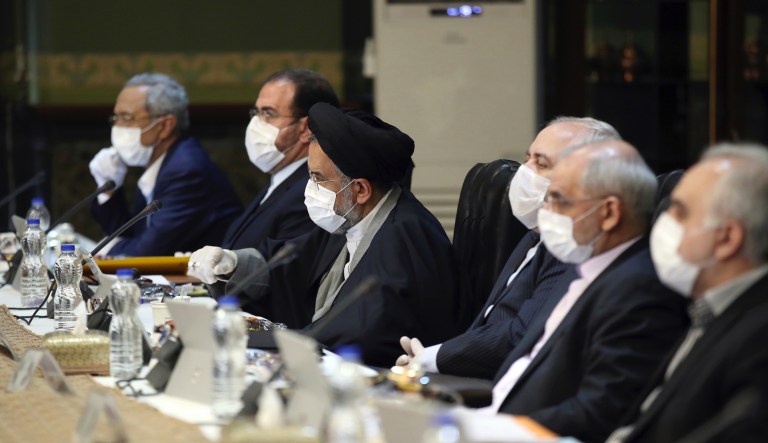 In this photo released by the official website of the Office of the Iranian Presidency, cabinet members wearing face masks and gloves attend their meeting in Tehran, Iran, Wednesday, March 18, 2020. 