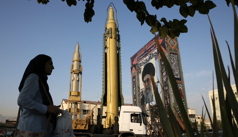 FILE- In this Sunday, Sept. 24, 2017 file photo, a Ghadr-H missile, center, a solid-fuel surface-to-surface Sejjil missile and a portrait of the Supreme Leader Ayatollah Ali Khamenei are displayed at Baharestan Square in Tehran, Iran, for the annual Defense Week which marks the 37th anniversary of the 1980s Iran-Iraq war. Iran's paramilitary Revolutionary Guard faces new sanctions from U.S. President Donald Trump as he has declined to re-certify the nuclear deal between Tehran and world powers. But what is this organization?