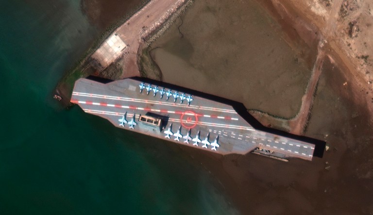 In this Feb. 15, 2020 satellite photo provided by Maxar Technologies, a mockup aircraft carrier built by Iran can be seen at Bandar Abbas, Iran, before being put to sea. Satellite photographs released Monday, July 27, 2020, showed Iran has moved the aircraft carrier out to sea likely for naval drills amid heightened tensions between Tehran and the U.S. 
