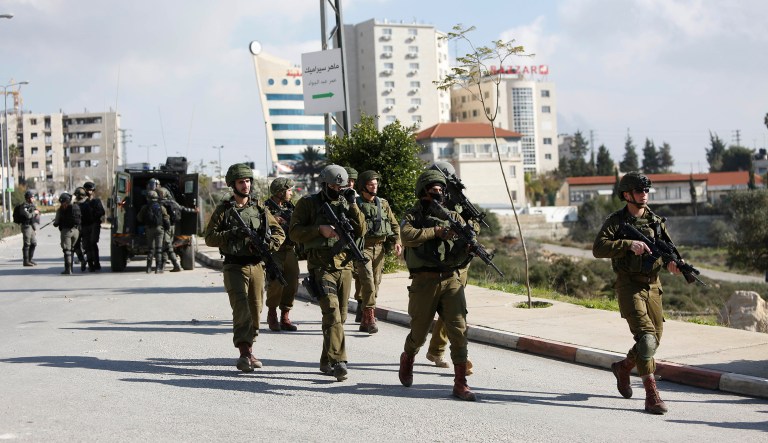Israeli soldiers conduct a search for suspects of a shooting attack yesterday in the West Bank City of Ramallah, Monday, Dec. 10, 2018. Israeli officials say seven people have been wounded, one critically, in a shooting by a suspected Palestinian assailant outside a Jewish settlement of Ofra in the West Bank.