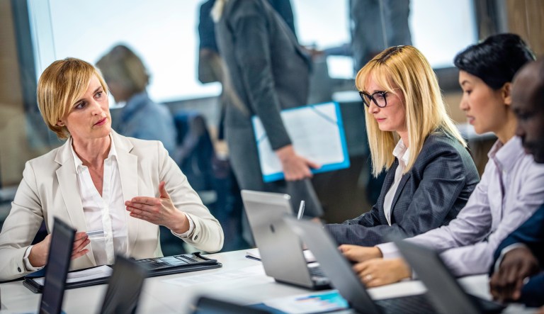 A female executive holds a meeting in the conference room.