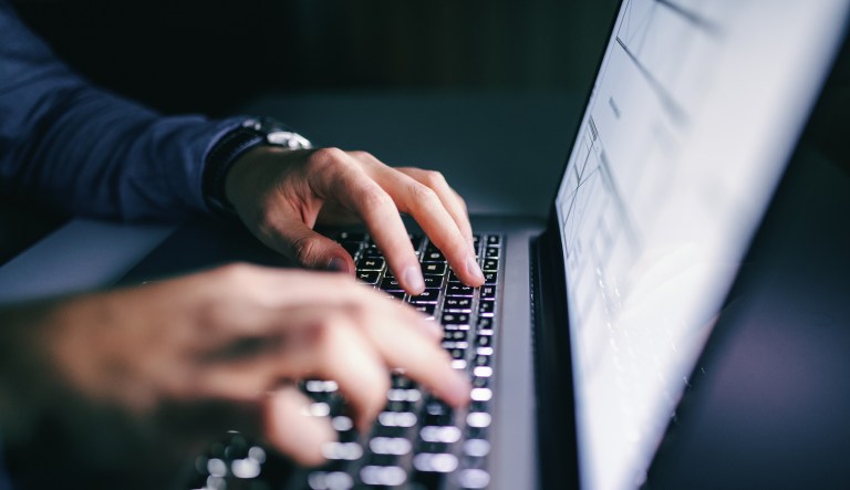 Close up of hands typing on laptop. 