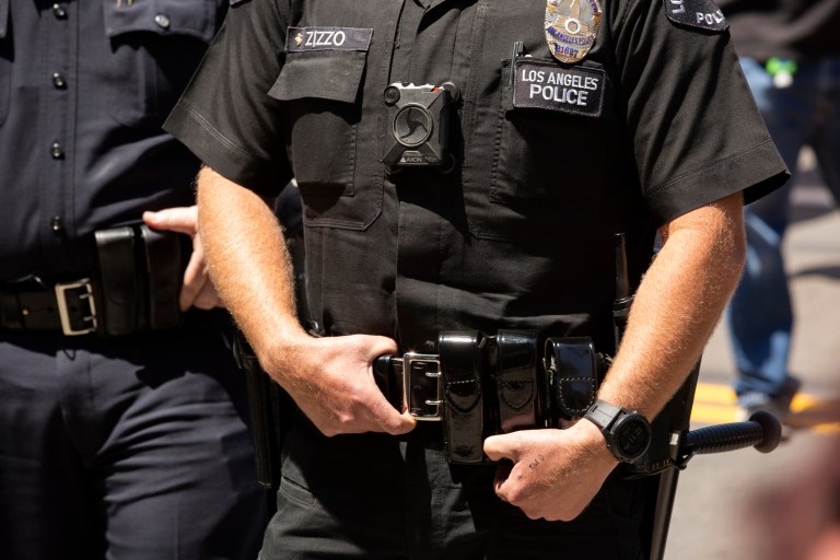 A Los Angeles Police Officer (LAPD) wearing a body camera stands watch outside of City Hall.